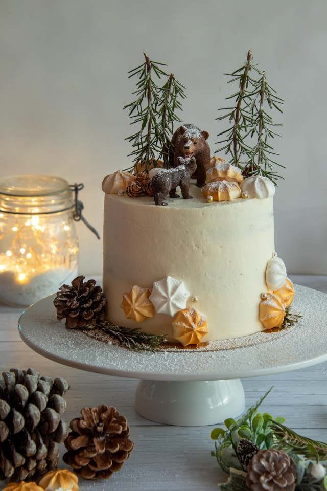 Winter wonderland forest cake with edible meringues, pinecones, and bear toppers from Cake Influenza bakery in Dumdum